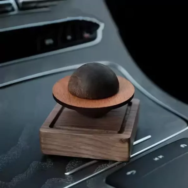 Planet-shaped wooden oil diffuser on a car console.