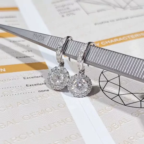 Round-cut moissanite diamond halo dangle earrings on tweezers with gemological report.