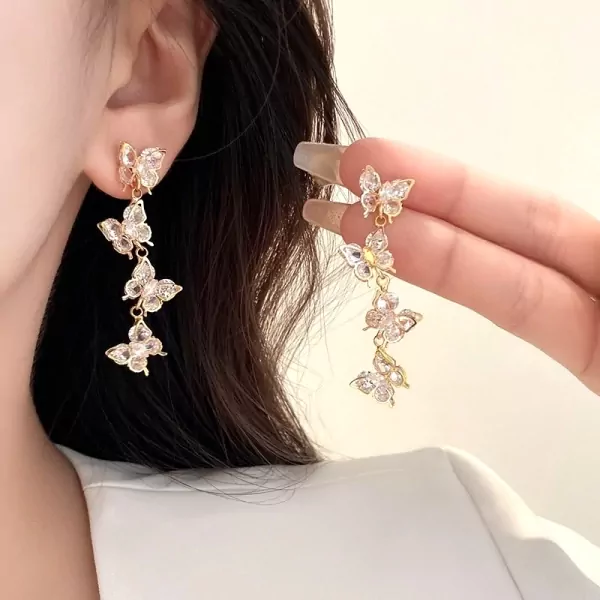 Gold drop earrings with three clear zircon butterflies cascading downwards.