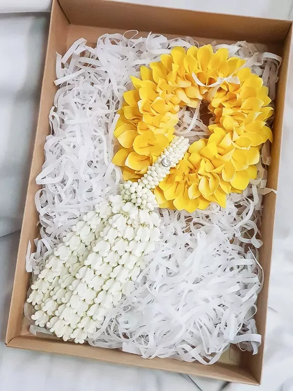 Yellow and white flower garland with sparkling detail in a gift box.