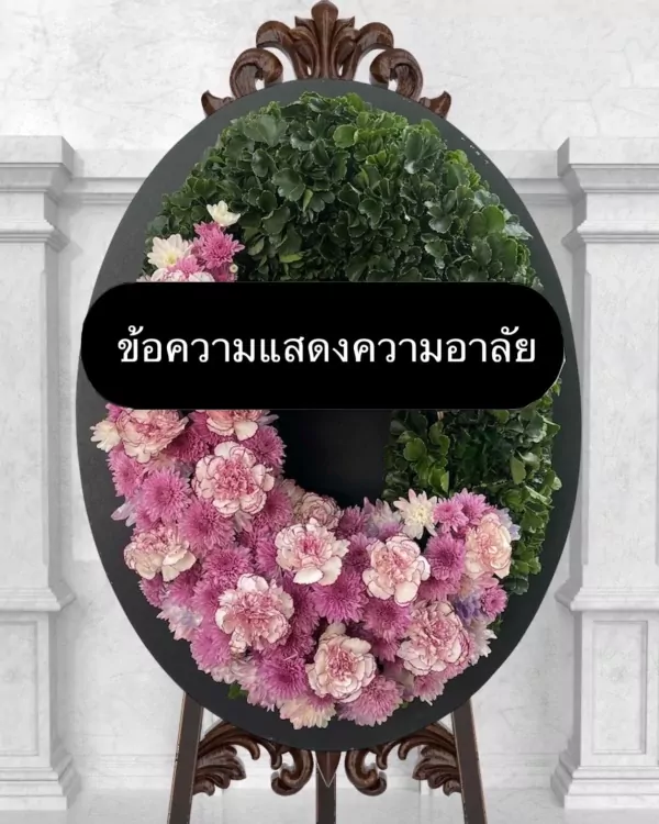 A floral wreath with pink and green flowers and a black sign with Thai text.