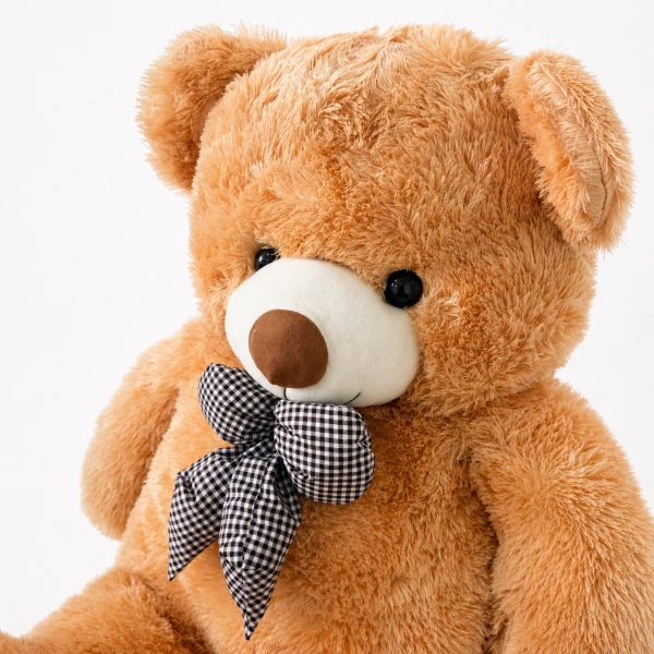 Giant teddy bear, brown, fluffy, wearing a checkered bow tie, against a white background.