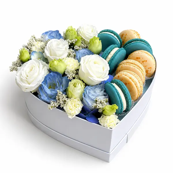 Heart-shaped box with blue and white flowers and macarons.