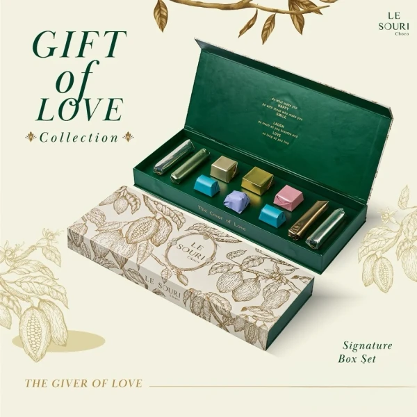 Le Souri Signature Chocolate Box with assorted chocolates and foil-wrapped bars inside an open green box.