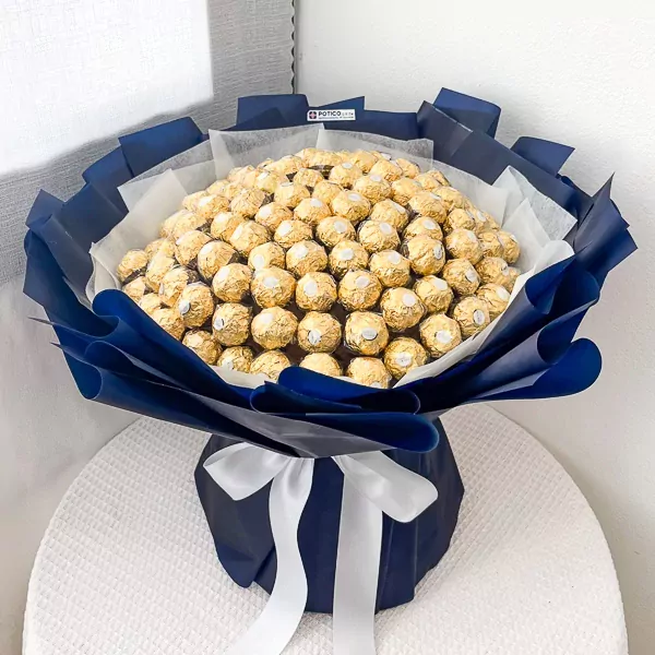Bouquet of 100 gold-wrapped Ferrero Rocher chocolates in dark blue and white paper, tied with white ribbon.