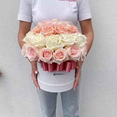 Round white box filled with 40 pastel pink and white roses, tied with a pink ribbon.