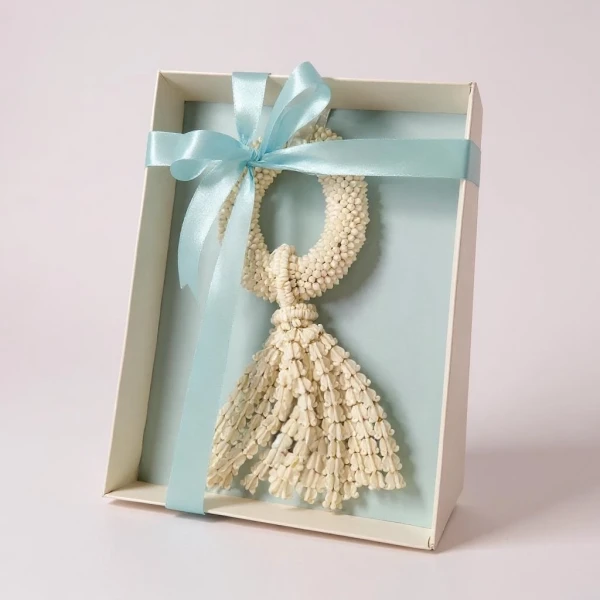 White jasmine garland with blue ribbon in a gift box.