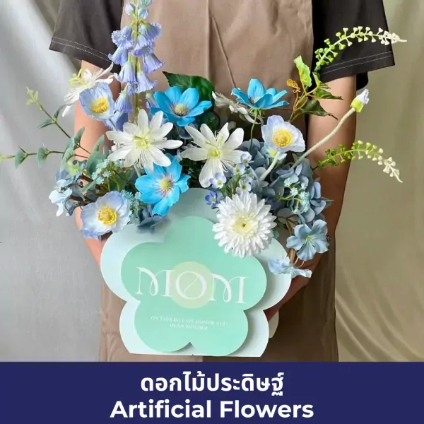 Artificial flower arrangement in blue and white with a "MOM" sign.