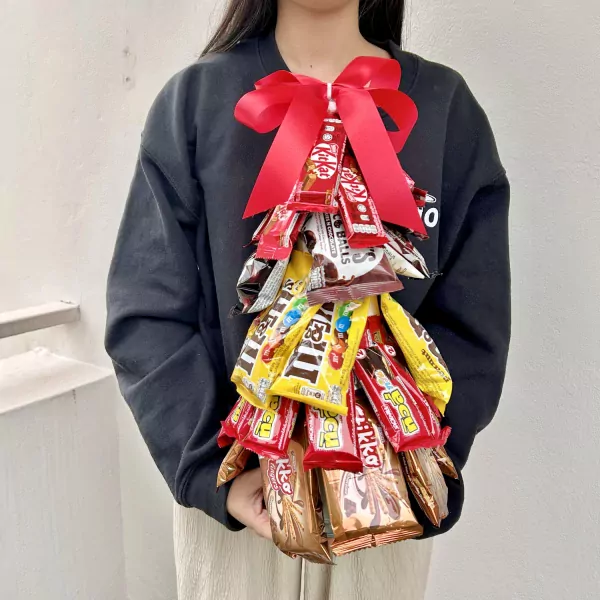Chocolate Christmas tree arrangement with red bow, made of Kit Kat, M&M's and other chocolate bars.