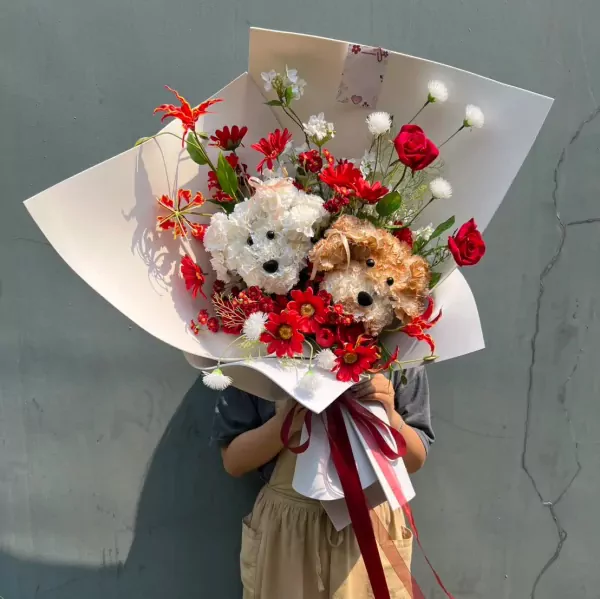Bouquet of two puppy-shaped floral arrangements in red and white flowers.