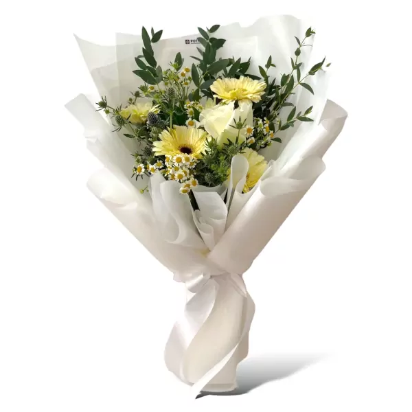 White roses and yellow gerberas in a white paper bouquet with a ribbon.