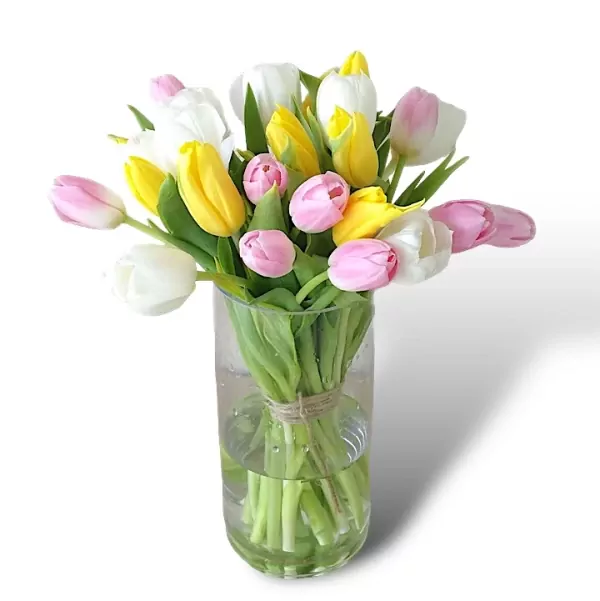 A clear vase filled with 25 mixed color tulips, tied with twine.