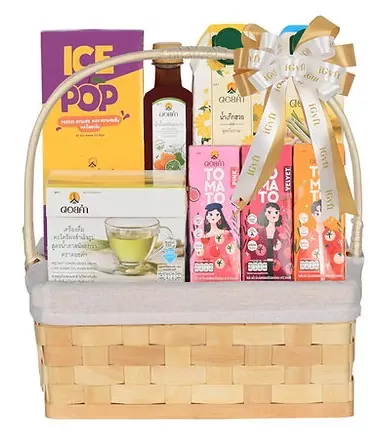 Gift basket with Doi Kham beverages, tea, and snacks, featuring bright packaging and a festive bow.