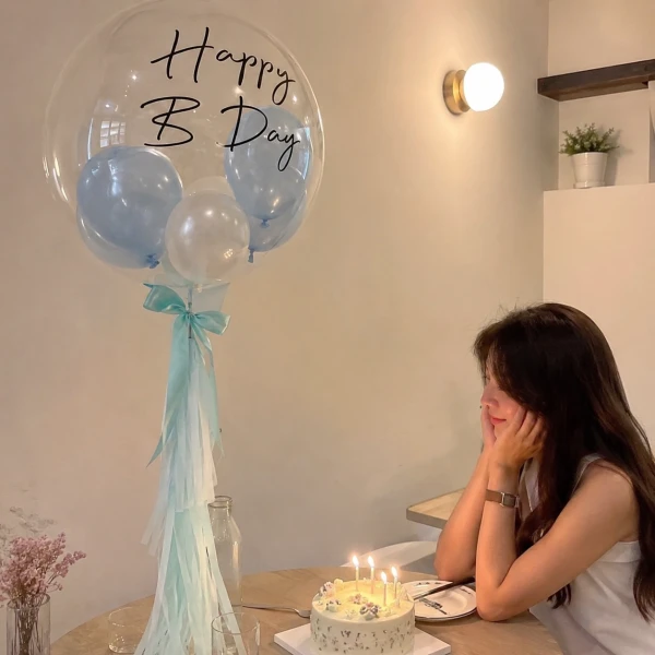 24" bubble balloon with "Happy B Day" text, filled with blue and white mini balloons and light blue tassels.