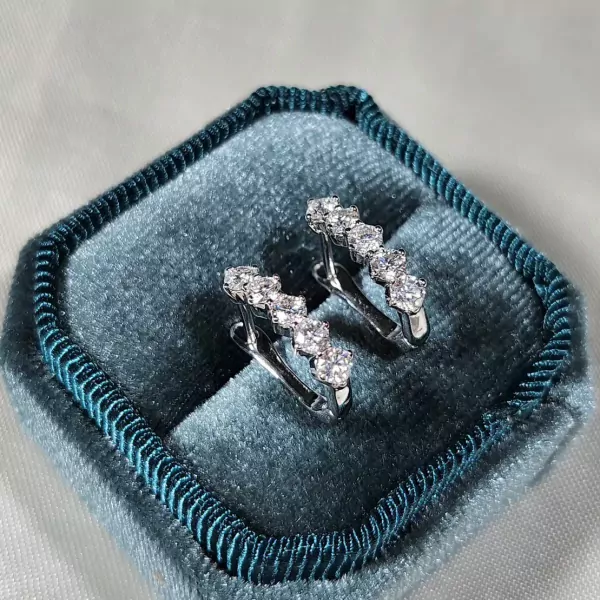Diamond-studded dangling earrings in a velvet jewelry box.