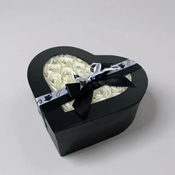 Heart-shaped black box with white roses, black ribbon, and graduation cap pattern.