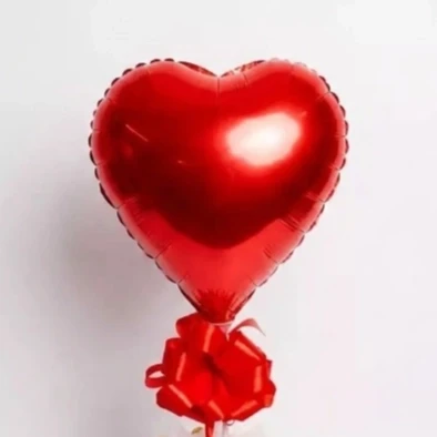 Red heart-shaped foil balloon tied with a red bow against a white background.