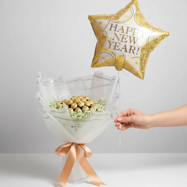 Ferrero Rocher bouquet with white gypsophilia, wrapped in white paper and tied with a peach ribbon, topped with a "Happy New Year" star balloon.