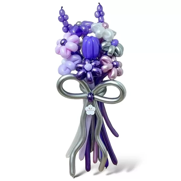 Purple balloon bouquet featuring flowers and a bow against a white background.