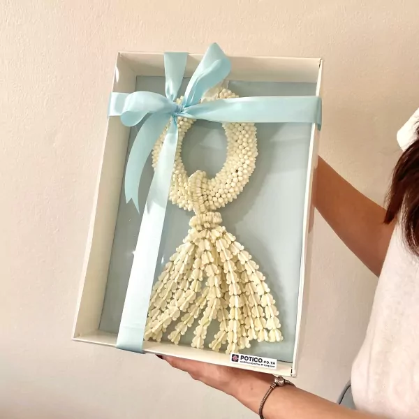 A white jasmine garland with a blue ribbon in a box.