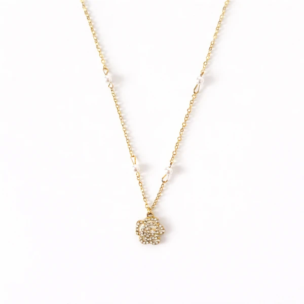 Gold necklace with a rose pendant and small pearl accents.