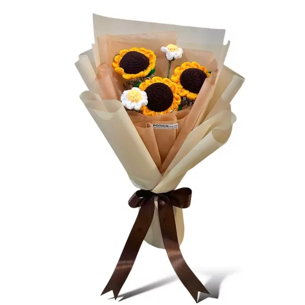Crocheted bouquet of sunflowers and daisies with a brown ribbon, wrapped in light brown and cream paper.