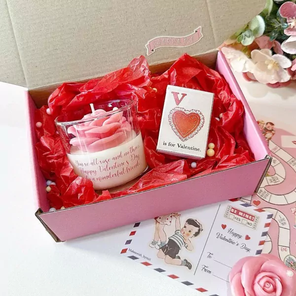 Valentine's gift box with rose candle, "V is for Valentine" card, and love-themed decorations.