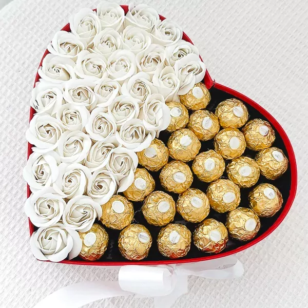 Heart-shaped box with white roses and Ferrero Rocher chocolates, tied with a white ribbon.