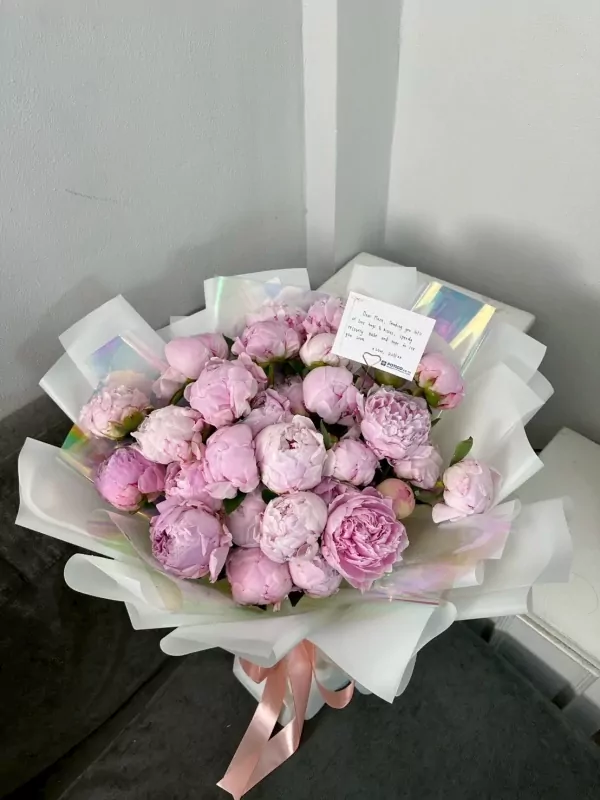 Bouquet of 30 pink peonies with a handwritten note, tied with a pink ribbon.