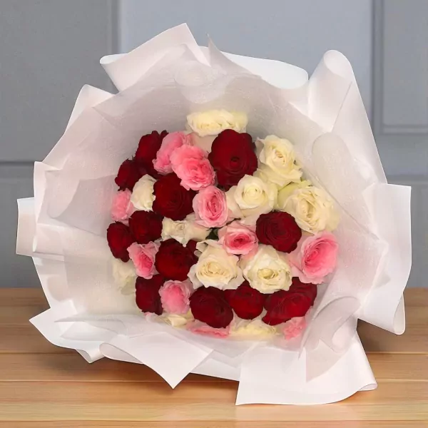 A bouquet of 30 white, pink, and red roses wrapped in white paper.