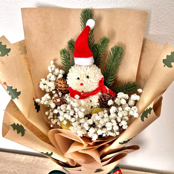 Christmas bouquet with two snowman ping pong flowers, pine leaves, and pinecones.