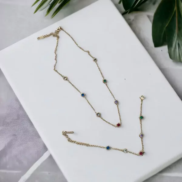 Gold-tone necklace and bracelet set with small colorful gemstones.