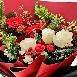 Red and white Christmas bouquet with roses, gerberas, carnations, and pine.