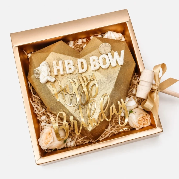 Golden heart-shaped chocolate with "Happy Birthday" text in a gift box with a hammer.