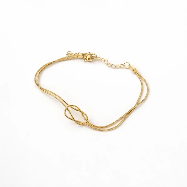Gold-tone bracelet with double strands and an infinity knot centerpiece on a white background.