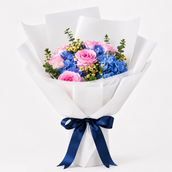 Pink roses, blue hydrangeas, and daisies in white paper wrap, tied with a dark blue ribbon.