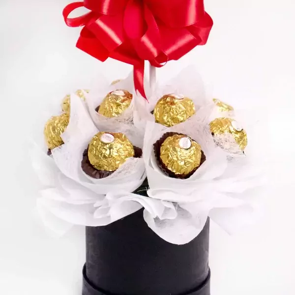 Ferrero Rocher chocolates arranged in a black box with a red bow.