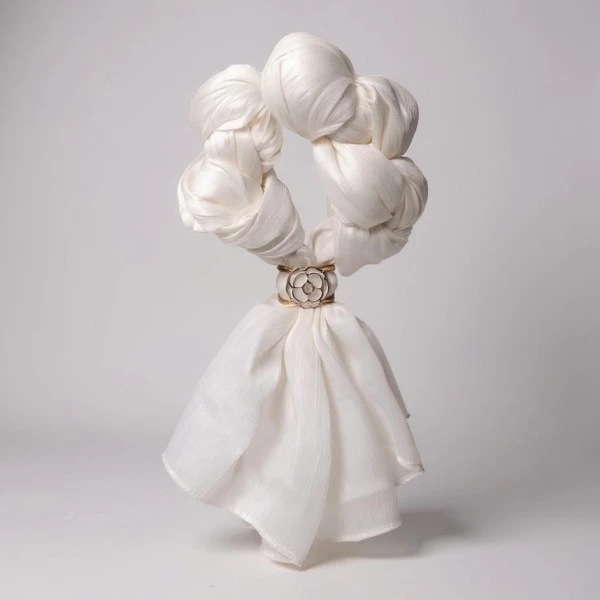 White scarf tied into a circle with a floral ring, resembling a garland.