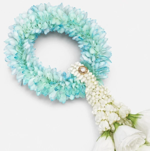 A light blue and white flower garland with white roses at the bottom.