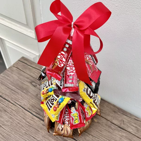 Chocolate Christmas tree arrangement with red bow, made of Kit Kats and M&Ms.