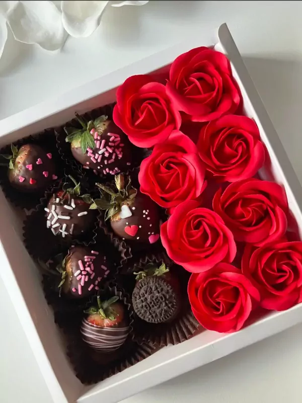 A box of chocolate-covered strawberries and red roses.