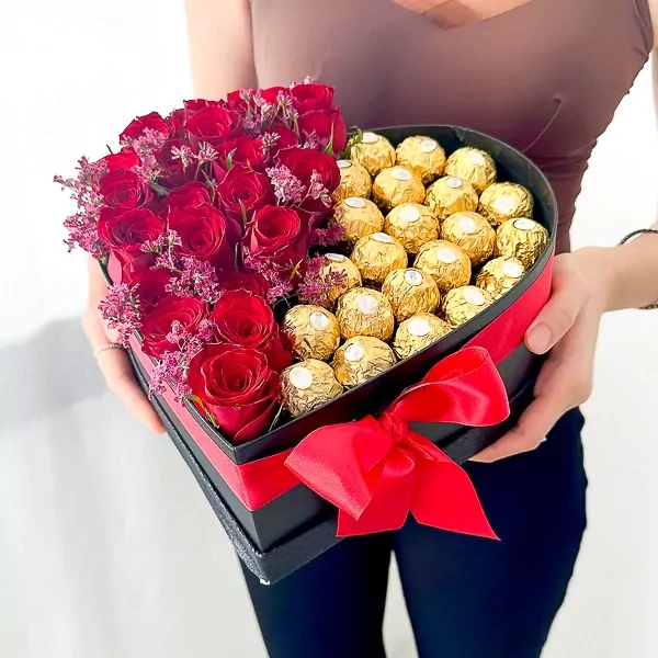 Heart-shaped box with red roses and Ferrero Rocher chocolates, tied with a red ribbon.