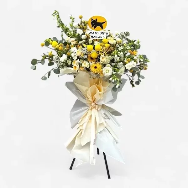 A grand opening floral stand with yellow and white flowers, featuring a black cat logo.