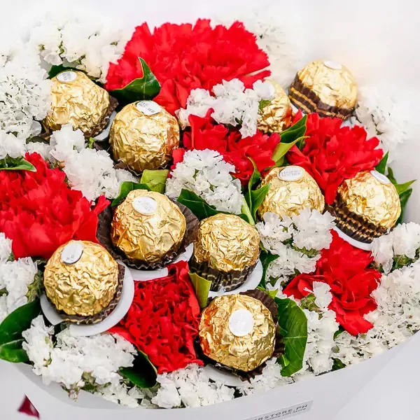 Bouquet of red carnations, white statice, and Ferrero Rocher chocolates.