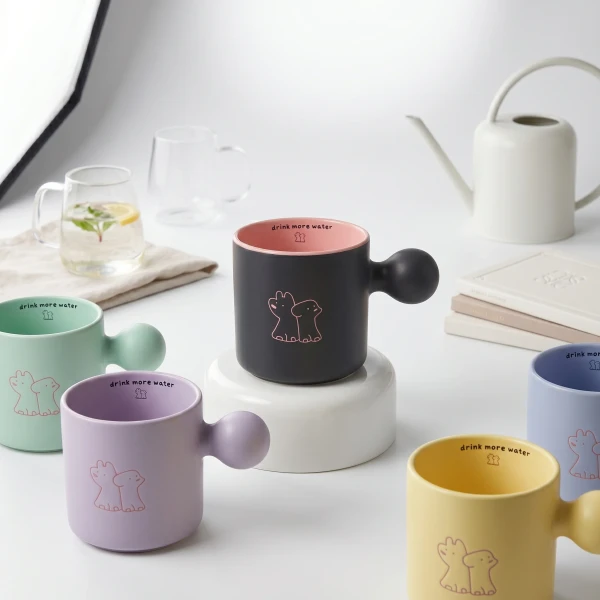 Pastel puppy mugs with "drink more water" text and dog illustrations.