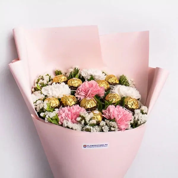 Bouquet of pink and white carnations and Ferrero Rocher chocolates, wrapped in pink paper.