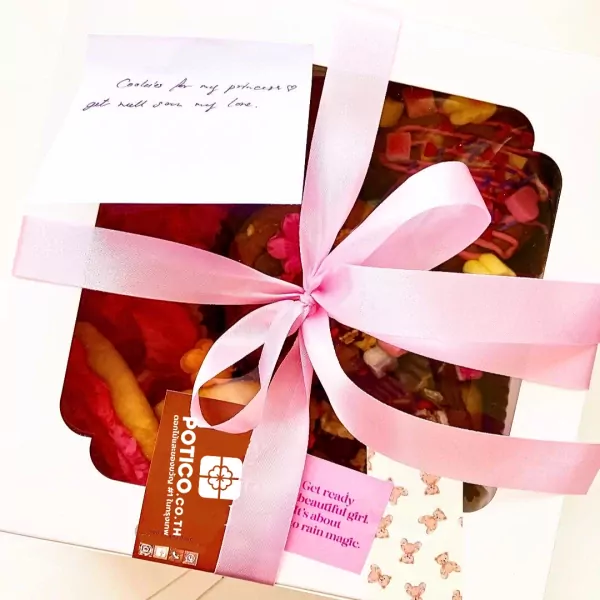 Gift box with pink ribbon, handwritten note, and Frosted Sugar Cookies Box.