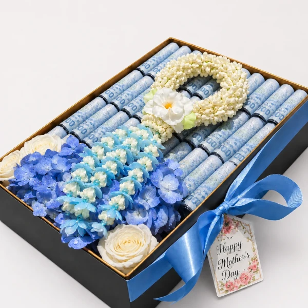 luxury golden gift box featuring 30 neatly rolled banknotes, paired with a spiraled Crown Flower garland and fresh blue blooms