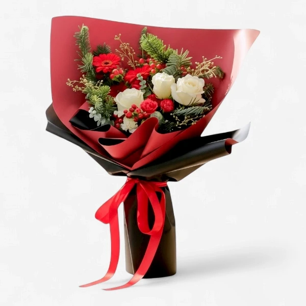 White and red roses, gerberas, and pine in a festive bouquet wrapped in red and black paper with a red ribbon.