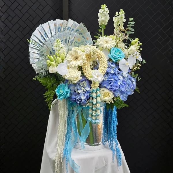 luxury blue-and-white fresh floral bucket featuring an impressive banknote fan and a handcrafted fresh jasmine garland